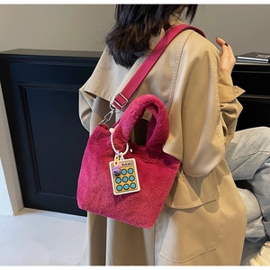 Detailed view of rose purple plush bucket bag with wide strap and 666 charm