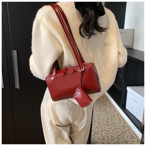 Detail view of a vintage dark red glossy shoulder bag with a matching mini coin purse hanging