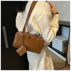 Brown sleek minimalist shoulder bag with matching mini pouch shown on a model