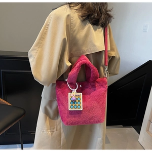 Detail of vibrant rose pink plush tote bag with furry texture and a calculator charm