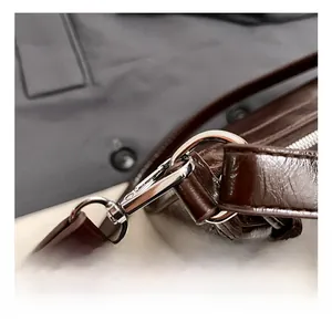 Macro shot of silver metal hook and premium glossy leather texture with fine stitching detail