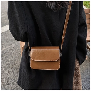 Brown vintage square crossbody bag shown on model back view in outdoor street style