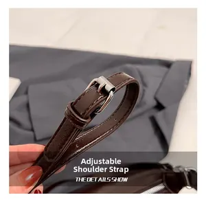 Close-up of adjustable dark brown leather shoulder strap with silver metal buckle detail