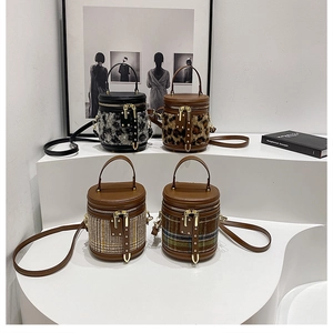 Detalle de cuatro bolsos de cubo cilíndricos en leopardo y cuadros con adornos de cuero y oro