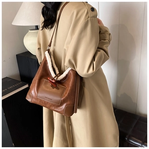 Detail der braunen Retro-Tasche mit flauschigem Teddyfell-Besatz und Knebelverschluss