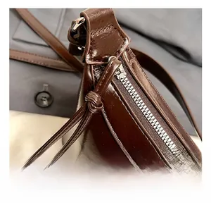 Macro view of polished brown faux leather texture and premium silver metal zipper detail