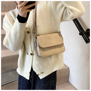 Detail of minimalist beige PU square crossbody bag with metal zipper and adjustable strap
