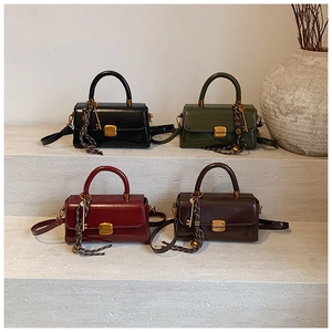 Detail view of four retro patent leather handbags with vintage gold clasps and key charms