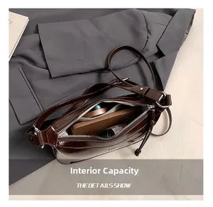 Detail showing internal capacity of the dark brown leather bag with personal items