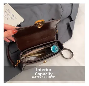 Detail view of the dark brown leather handbag interior with a zip pocket and open flap