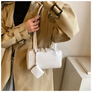 Detail of white rectangular leather shoulder bag with matching mini coin purse and dual zippers