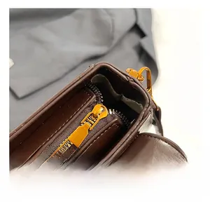 Macro shot of high-quality gold hardware and zipper on a dark brown leather handbag
