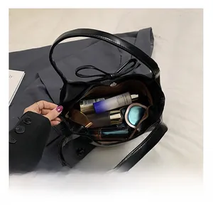 Vue de dessus du sac en cuir mat noir montrant l'intérieur spacieux et la doublure rayée