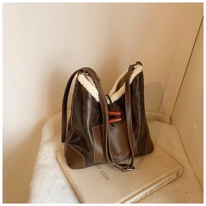 Detail der braunen Leder- und Sherpa-Beuteltasche mit Holz-Knebelverschluss