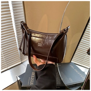 Detailed close-up of dark brown vintage faux leather shoulder bag with glossy finish