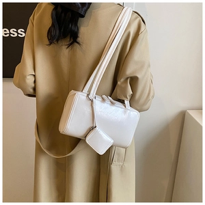 White faux leather rectangular pillow bag shown on model with matching coin purse charm
