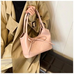 Détail du nœud en similicuir rose et du logo gaufré sur ce sac cabas élégant