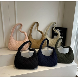 Close-up of quilted hobo bags in six stylish colors on a minimal white display stand