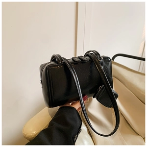 Detail of glossy black patent leather shoulder bag with a matching mini coin purse
