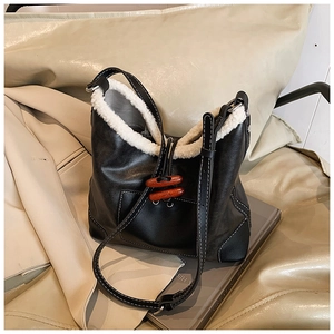 Detail der schwarzen Vintage-Beuteltasche mit Fleecefutter und Holzknöpfen für den Winter