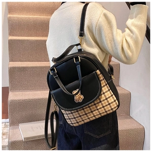 Detail of stylish color-block plaid backpack featuring a golden bear embroidery