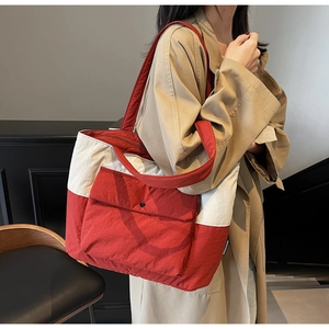 Close-up of red and white large capacity quilted tote bag with outer button pocket