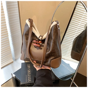 Detailansicht der braunen Vintage-Beuteltasche mit weißem Plüschrand und Knebelverschluss