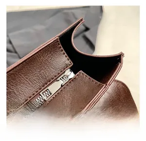Close-up of smooth silver rectangular zipper on brown lychee texture leather backpack