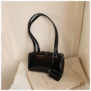Detail of minimalist black faux leather shoulder bag with detachable mini coin purse