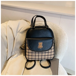 Detail of a chic two-way backpack with brown plaid fabric and a cute bear embroidery