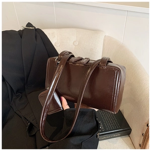 Detail of a dark brown glossy faux leather shoulder bag with a mini detachable pouch