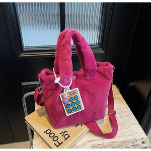 Detail of fuchsia plush bucket bag with soft faux fur texture and cartoon charm