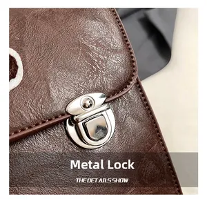 Detail of vintage dark brown leather backpack with silver metallic hardware clasp closure