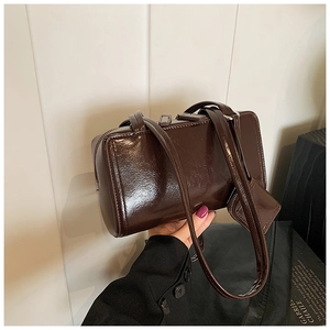 Detailed view of deep brown glossy leather Boston bag with matching coin purse charm