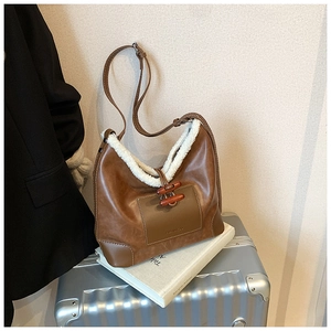 Detail der braunen Ledertasche mit Wollbesatz und doppelten Knebelverschlüssen aus Holz