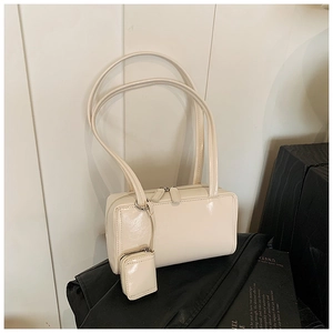 Close-up of cream rectangular shoulder bag with matching mini coin purse attachment