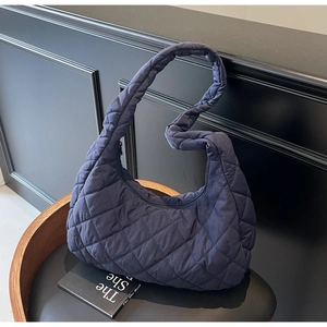 Detail view of navy blue quilted shoulder bag featuring premium puffy rhombus stitching