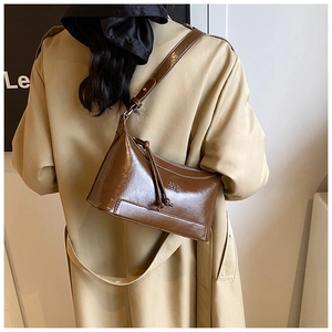 Brown patent leather pillow bag shoulder carry view on model showing retro style texture