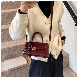 Detaillierte Ansicht der tiefroten Lackleder-Handtasche mit goldener Schließe und Seidenschal
