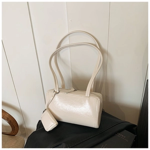 Detail view of cream white faux leather pillow bag with matching mini coin purse