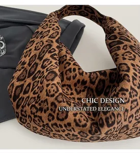 Top view of large leopard print hobo bag with seamless strap on white textured background
