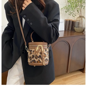 Bolso cubo de piel sintética de leopardo marrón con ribete de cuero y cremallera dorada