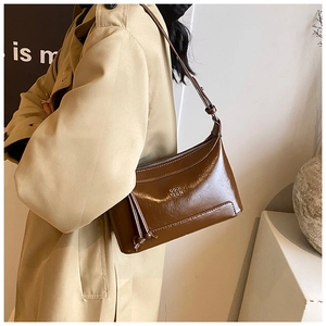 Brown oil wax leather pillow shoulder bag with retro tassel detail and brand embossing