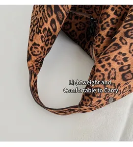 Close-up of leopard print suede handbag with black zipper and soft matte texture detail