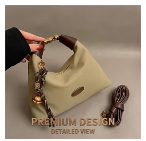 Détail du sac en nylon kaki avec pendentif en corde tressée et clochette dorée
