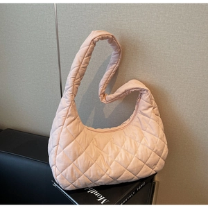 Detailed close-up of pink quilted puffer bag with rhombic pattern and soft nylon texture