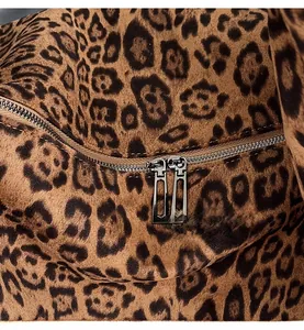 Detail of smooth metal hardware zippers on luxury leopard print suede fabric tote bag