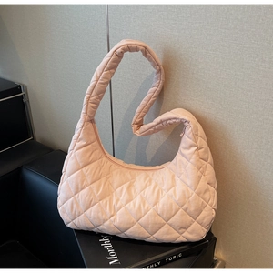 Close-up of light pink quilted diamond texture on a hobo shoulder bag with zipper detail
