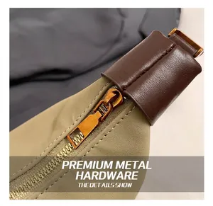 Détail du sac en nylon kaki montrant la fermeture dorée et le liseré en cuir brun