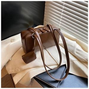 Detail of a dark brown glossy leather Boston shoulder bag with silver zippers and a small pouch